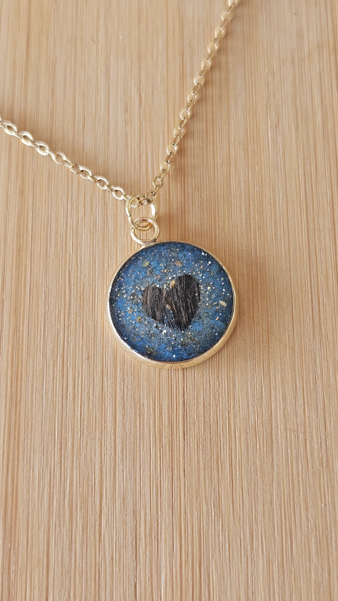 Blauer glitzernder Resin-Anhänger mit einem Herz aus Tierfell an einer goldfarbenen Kette