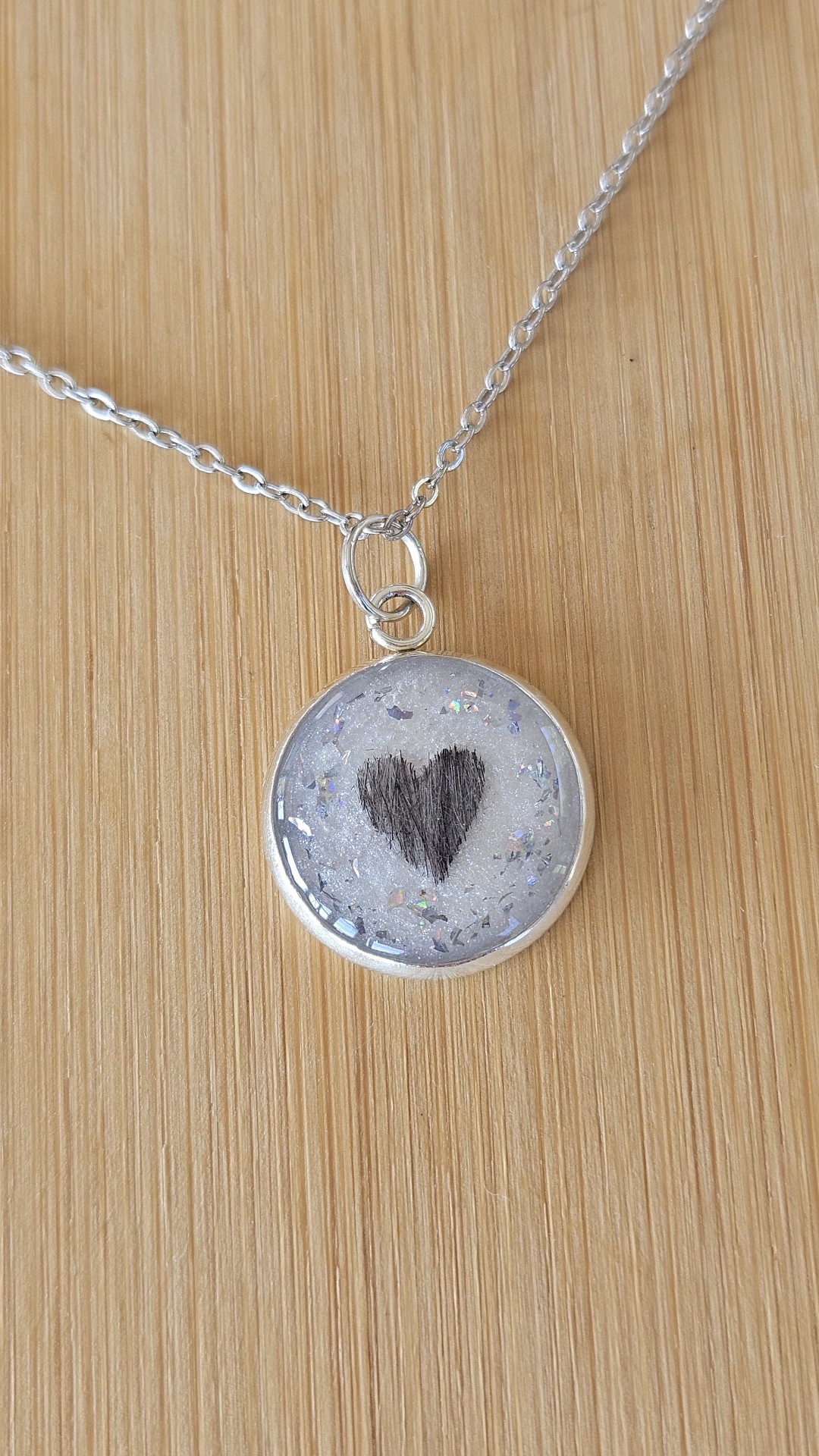 Silbrig schimmernder Resin-Anhänger mit Tierfell in Herzform